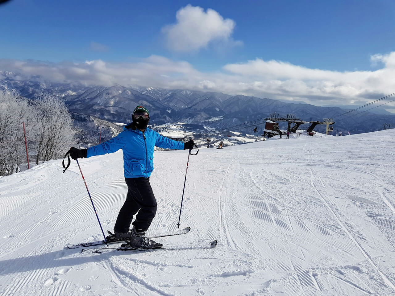 Naeba Ski Resort highland view, skier overlooking a vast snowy mountain landscape